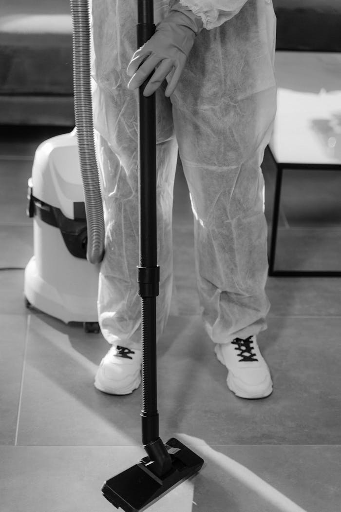 services-03 Monochrome image of a person in PPE vacuuming indoors. Suitable for COVID-19 and hygiene concepts.